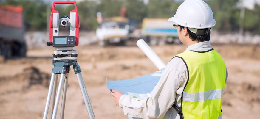 Surveyor using professional equipment to conduct a topographic site survey